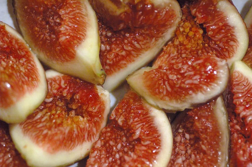 Mehrere halbierte reife Feigen mit rosarotem, körnigem Fruchtfleisch