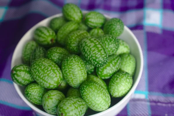 Reife Früchte der Mexikanischen Minigurke, jede so groß wie eine Weintraube, mit melonenartiger Musterung