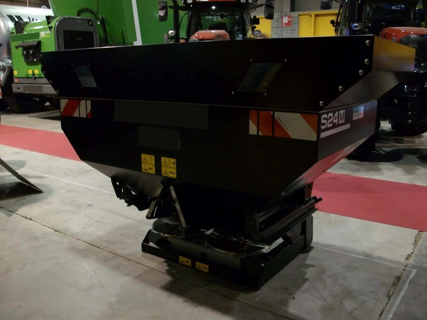 Streuwagen für Rasendünger mit Trichter und Streuscheibe auf dem Rasen