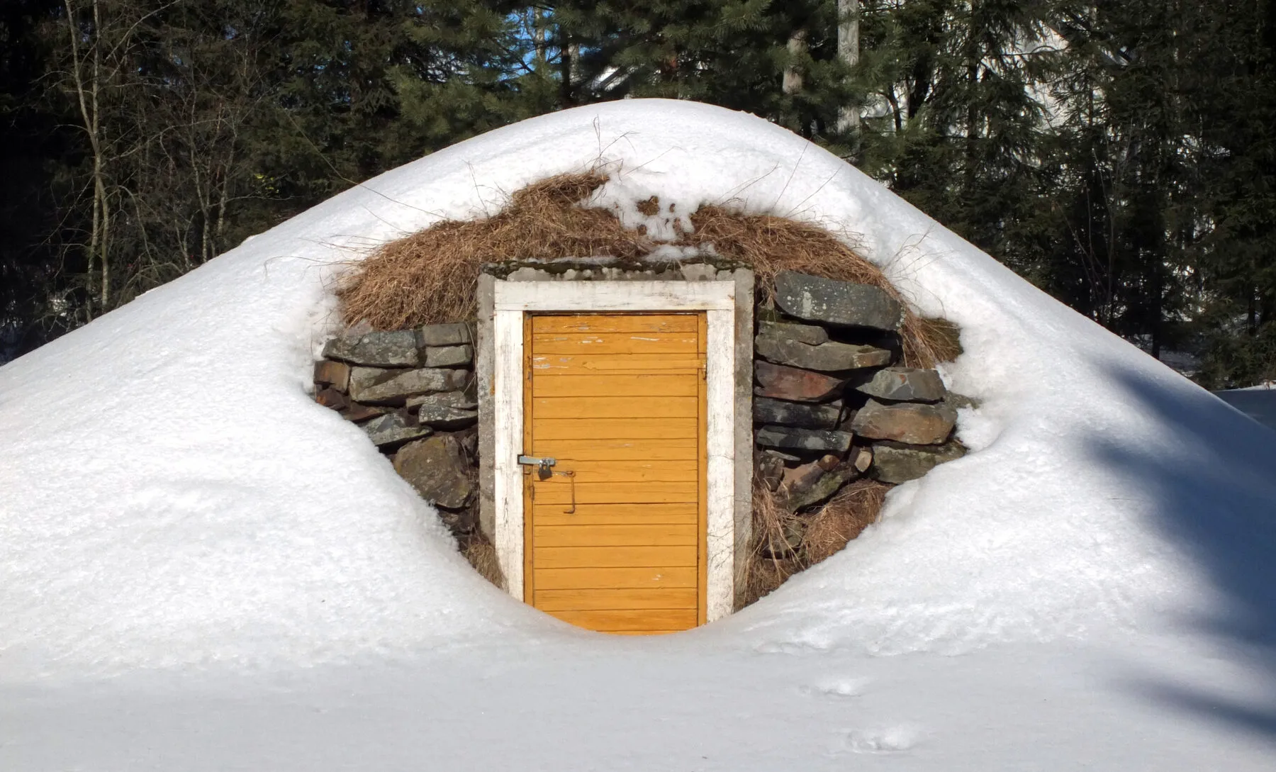 Eingang eines erdüberdeckten Erdkellers im Winter mit Schnee