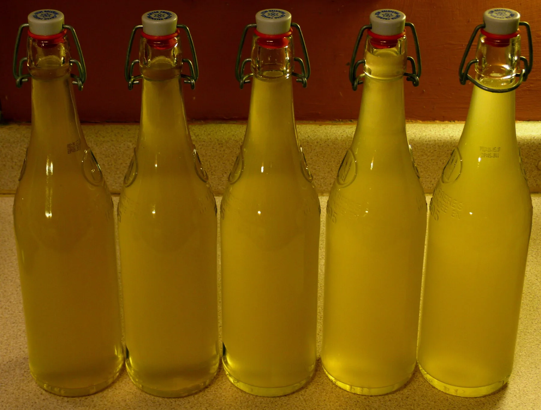 Mehrere Flaschen mit selbst gemachtem Holunderblütensirup auf einem Tisch