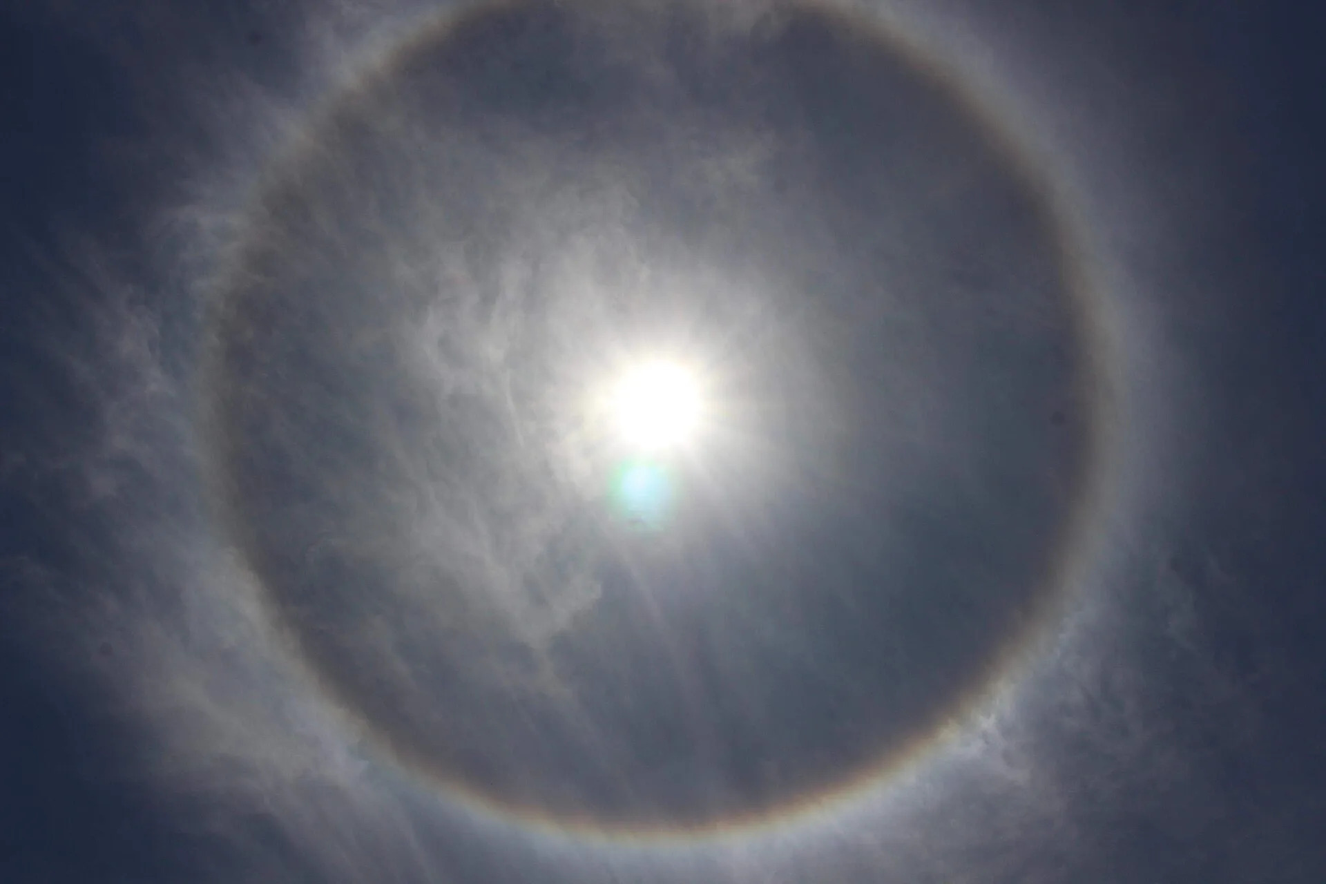 Heller Lichtring in 22 Grad Abstand um die Sonne an einem von dünnen Eiswolken bedeckten Himmel